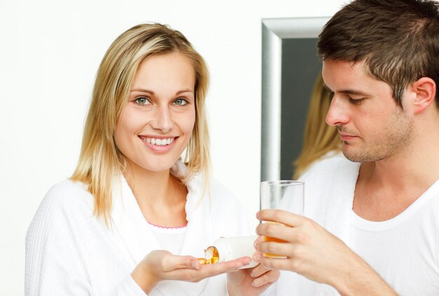 Hombre dando un vaso a su prometido para sus pastillas