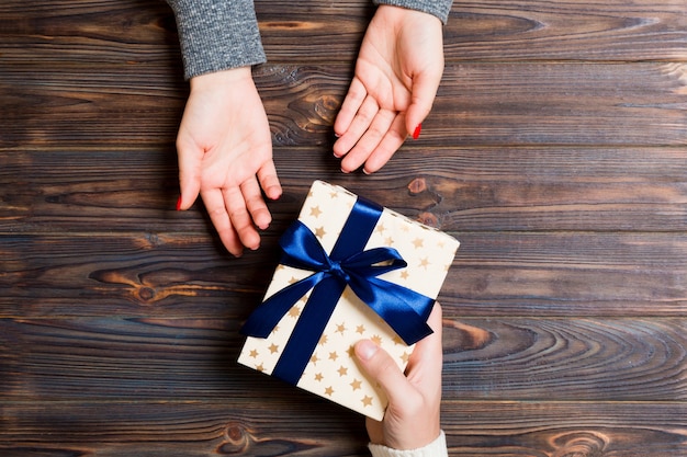 Hombre dar caja de regalo de Navidad en mano de mujer