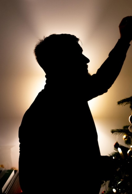 Foto hombre decorando el árbol de navidad