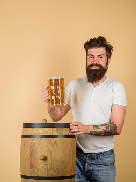 Hombre degustación de cerveza de barril en alemania pub de cerveza y bar barbudo sostiene un vaso con deliciosa cerveza