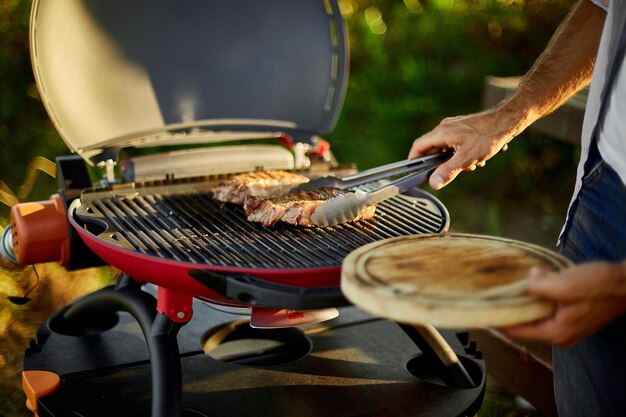 El hombre dejó la carne en una tabla de madera lista para comer carne de bistec a la parrilla