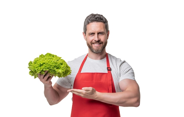 Hombre en delantal con lechuga vegetal aislado en blanco presentando producto