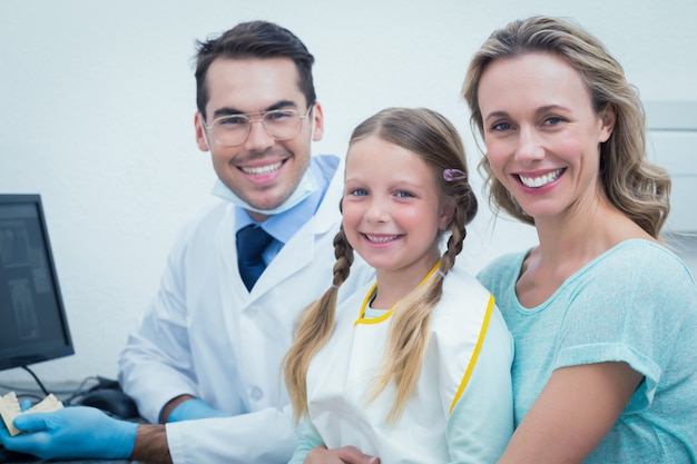 Hombre dentista con asistente y niña