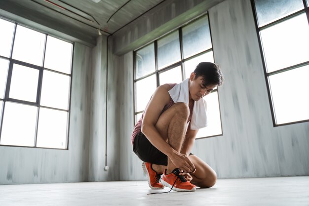 Foto hombre deporte atar sus zapatos antes de entrenar