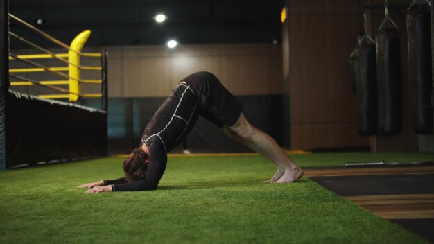 Foto hombre de deporte fuerte de primer plano calentándose en el gimnasio hombre de fitness energético haciendo ejercicios de estiramiento en el gimnasio boxeador masculino activo haciendo ejercicio en el club deportivo