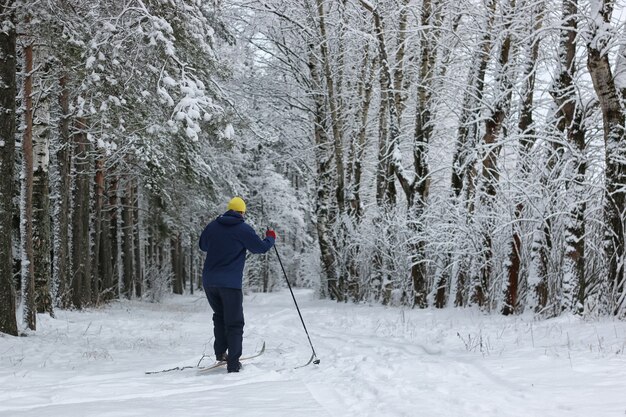 Hombre de deporte de nieve de invierno en el parque de árboles