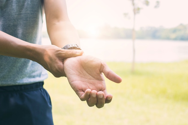 Hombre de deporte sufriendo heridas en la mano y el brazo como ejercicio y entrenamiento