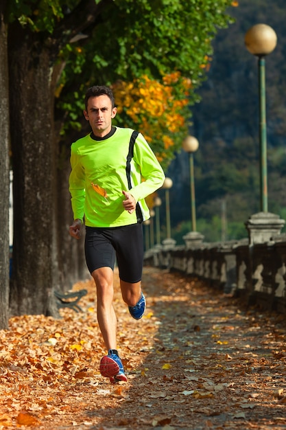 Hombre deportista corre en entrenamiento en otoño