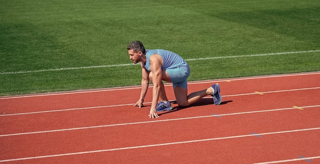 Hombre deportivo corriendo desde la línea de salida corriendo