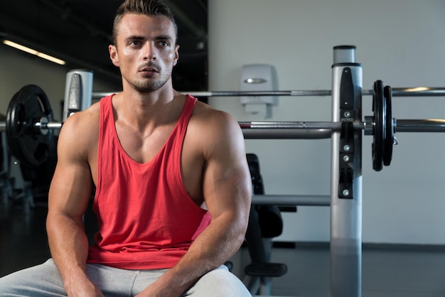 Hombre deportivo descansando en un gimnasio.