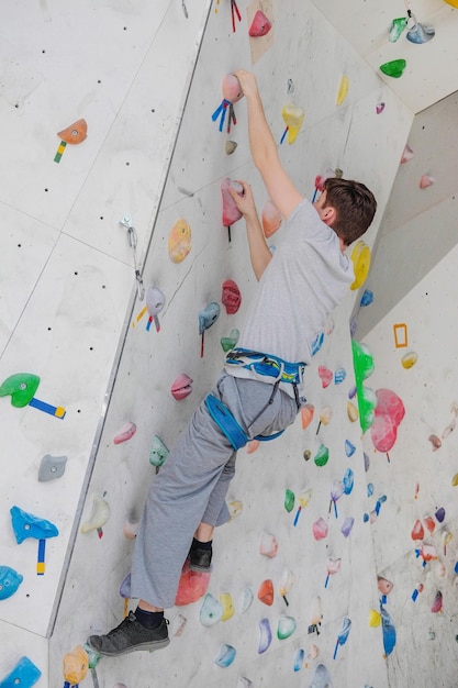Hombre deportivo escalada en muro de escalada