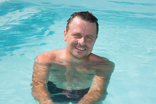 Hombre deportivo guapo en la piscina