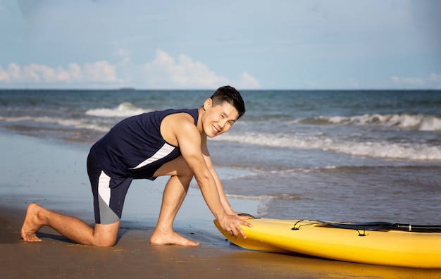 Hombre deportivo haciendo ejercicios en la playa en la mañana