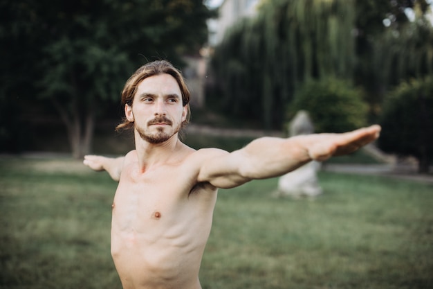 Hombre deportivo practicando yoga al aire libre