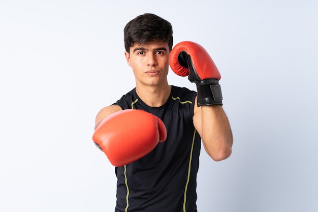 Hombre deportivo sobre pared azul con guantes de boxeo