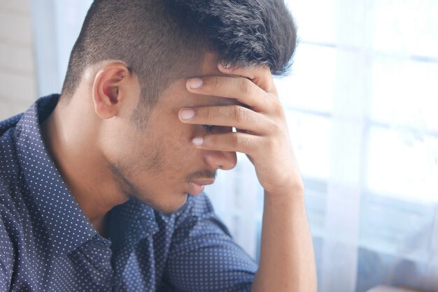 Foto hombre deprimido que se siente enfermo y preocupado por el problema financiero