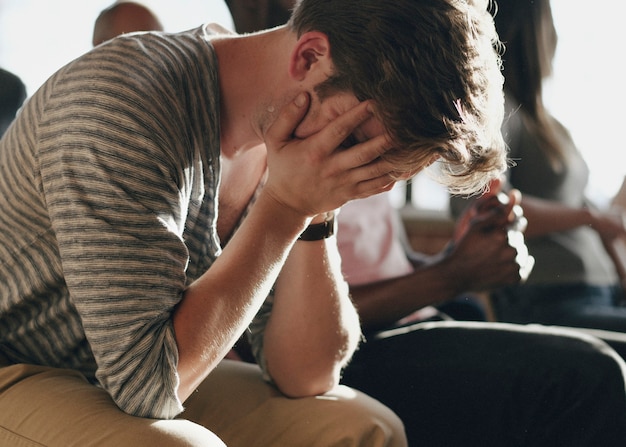 Foto hombre deprimido sentado en una sesión de rehabilitación