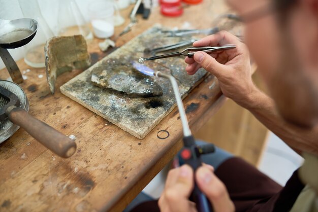 Hombre derritiendo metal en taller