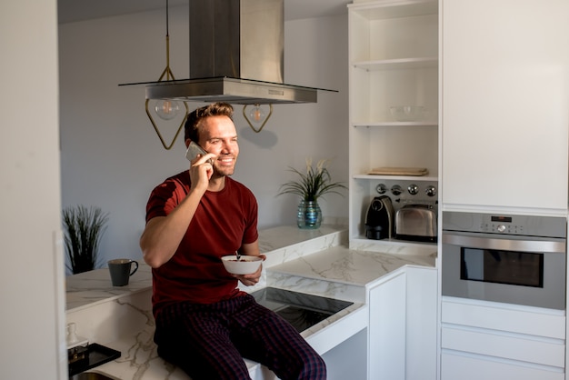 Hombre desayunando con teléfono móvil