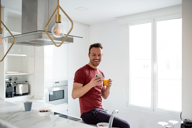 Hombre desayunando con teléfono móvil