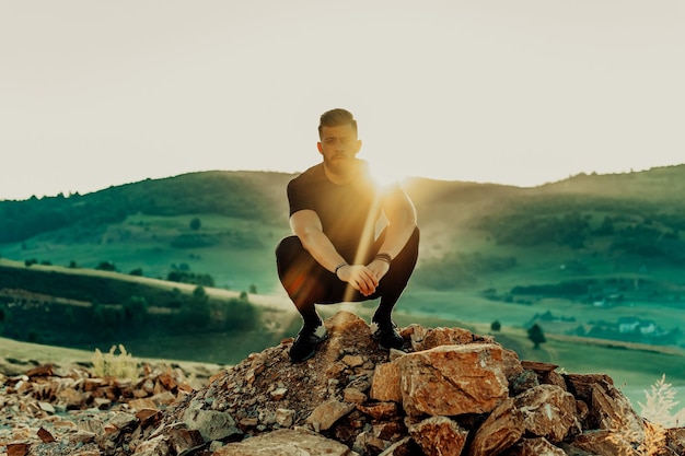 El hombre descansa en la cima de la montaña después del entrenamiento. Concepto de motivación