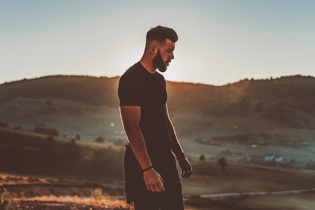 El hombre descansa en la cima de la montaña después del entrenamiento. Concepto de motivación