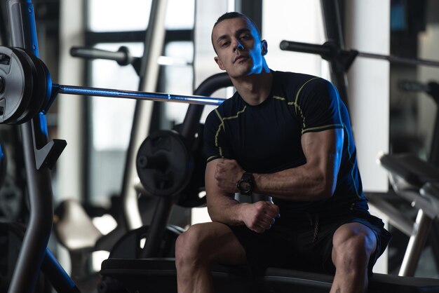 El hombre descansa en el gimnasio después de hacer ejercicio