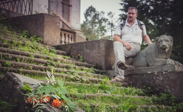 Un hombre descansa sobre los escalones de la antigua mansión.