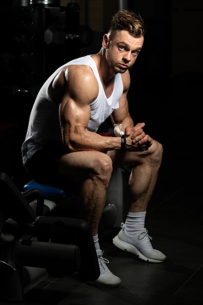 Hombre descansando en un banco en el gimnasio