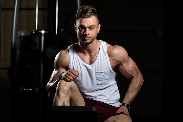 hombre descansando en un banco en el gimnasio