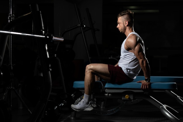 hombre descansando en un banco en el gimnasio