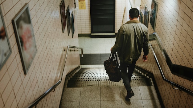 Hombre descendiendo de las escaleras hacia la estación de metro.