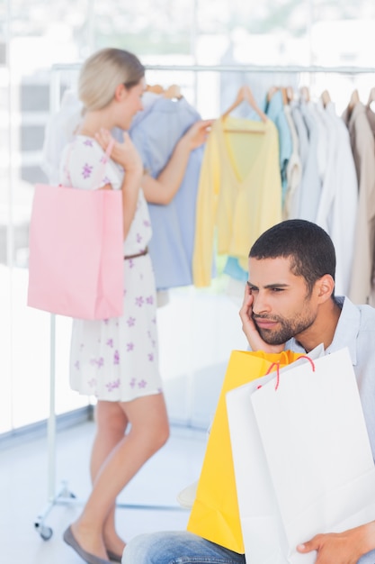 Hombre desesperado aburrido mientras su esposa está de compras