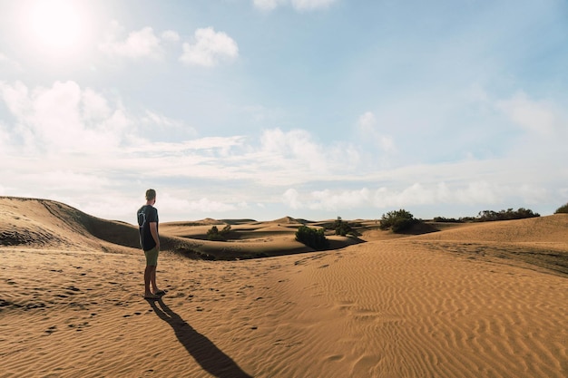 Hombre en el desierto de las dunas en un día soleado