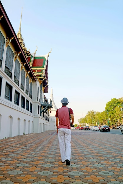 Hombre despertando a lo largo del patio exterior del complejo del Gran Palacio en Bangkok, Tailandia