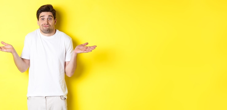 Foto hombre despistado encogiéndose de hombros extendió las manos hacia los lados confundido no sé nada de pie sobre backgr amarillo