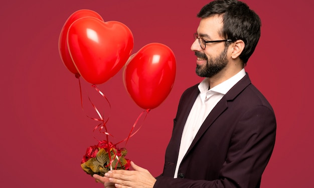 Hombre en el día de San Valentín aplaudiendo después de la presentación en una conferencia sobre fondo rojo