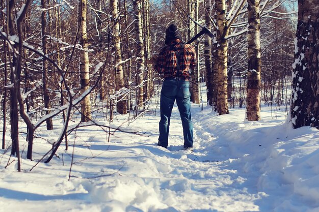 Hombre del día del sol con hacha en el bosque