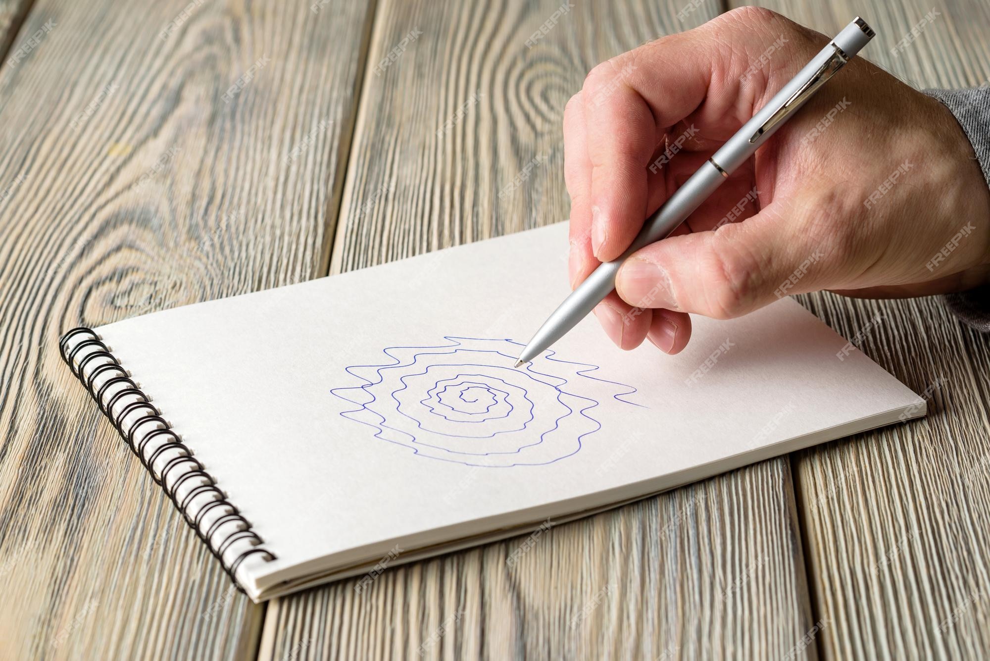 Un hombre dibuja una espiral desigual en un cuaderno prueba de temblor esencial y enfermedad de parkinson | Foto Premium Un hombre dibuja una espiral desigual en un cuaderno prueba de temblor esencial y enfermedad de parkinson | Foto Premium