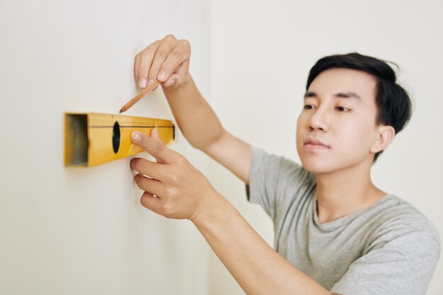 Hombre dibujando línea en la pared