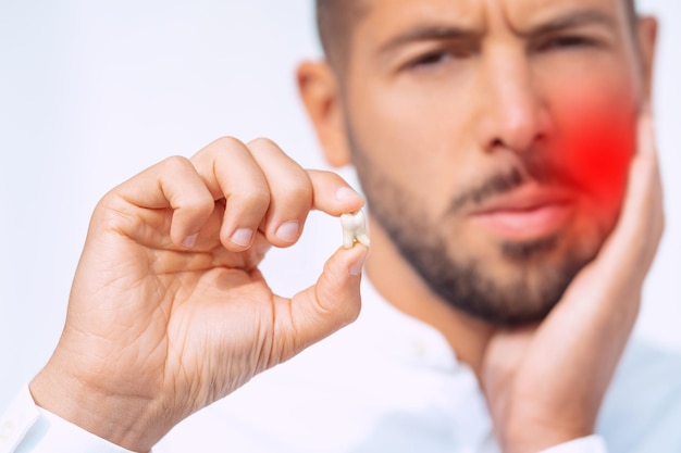 Hombre con diente extraído después de la cirugía de extracción del diente Dolor después de la extracción del diente