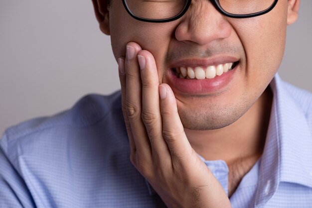 Hombre con dientes sensibles o dolor de muelas. Concepto de salud.