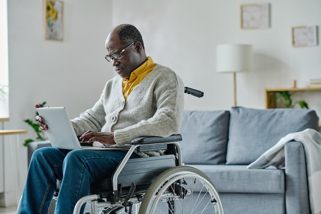 Hombre con discapacidad usando laptop en casa