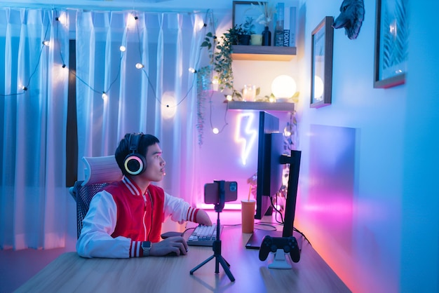 Foto hombre discapacitado con cascos rojos trabajando en una sala de computadoras con luz de neón creador de contenido