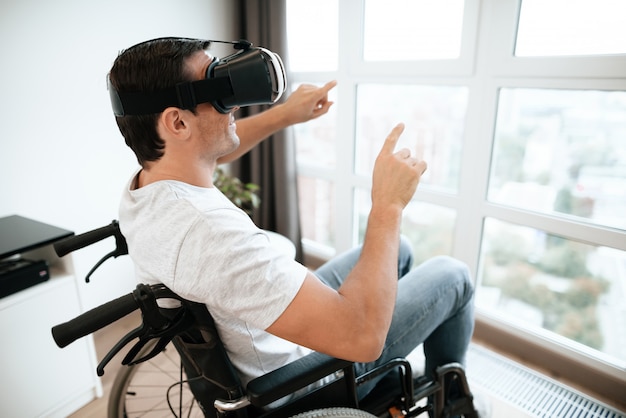 Hombre discapacitado disfruta de gafas VR con las manos arriba.