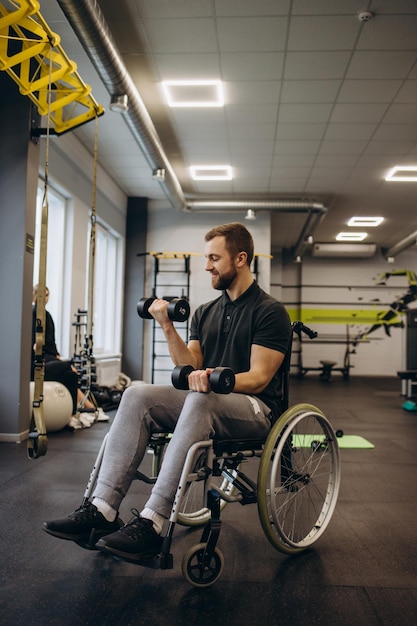 Hombre discapacitado entrenando en el gimnasio del centro de rehabilitación