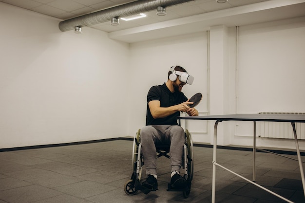 Un hombre discapacitado juega al ping pong digital usando tecnología de realidad virtual Concepto de tenis de mesa