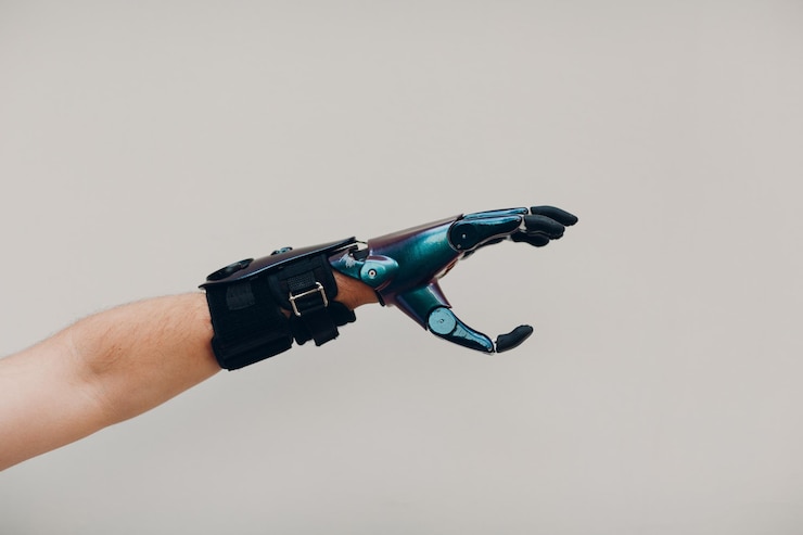 Foto hombre discapacitado con mano protésica artificial cerca de la mano contra el fondo gris