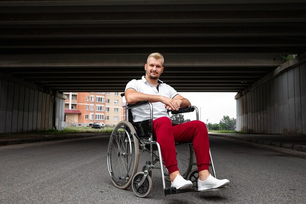 Foto un hombre discapacitado está sentado en una silla de ruedas en la calle. el concepto de silla de ruedas, persona discapacitada, vida plena, paralizada, persona discapacitada, atención médica.