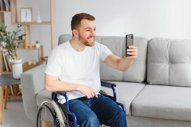 Hombre discapacitado en silla de ruedas haciéndose un selfie